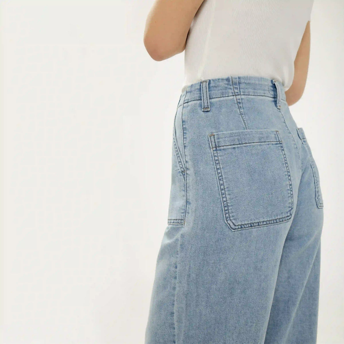 Silver wide leg knit flex denim jeans in light wash. Relaxed fit with classic back pockets and soft, stretchy denim texture.