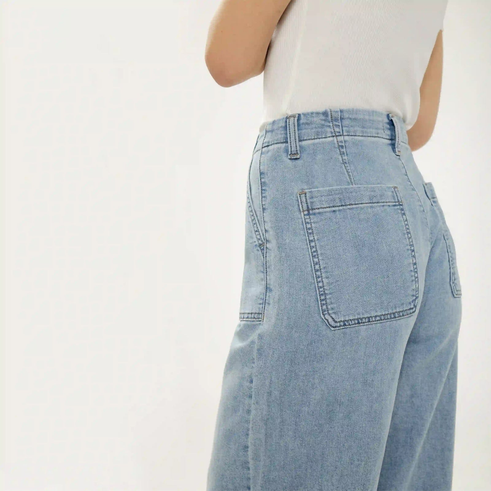 Silver wide leg knit flex denim jeans in light wash. Relaxed fit with classic back pockets and soft, stretchy denim texture.