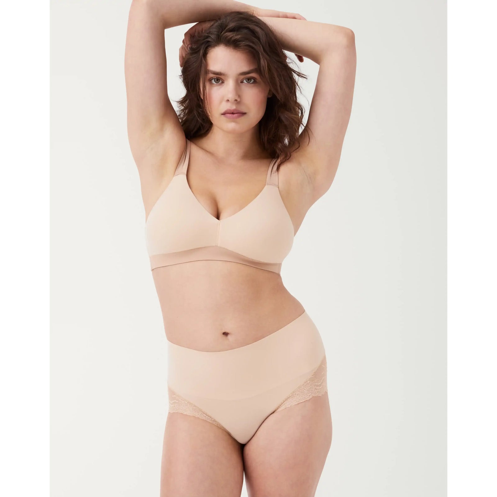 Model wearing SPANXsmooth Undie-tectable Lace Hi-Hipster in nude, seamless waistband and smooth silhouette.