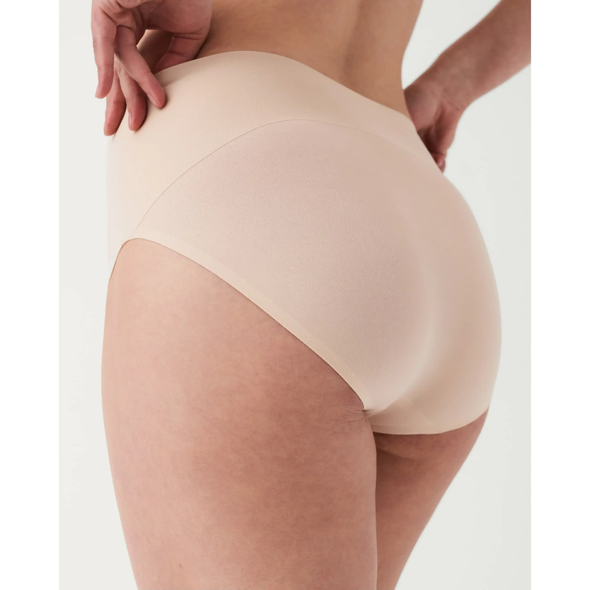 Spanx Undie-tectable Smoothing Brief on a model; seamless edges and bonded waistband for a smooth, no-VPL silhouette.