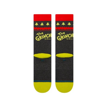 Black Grinch crew socks featuring yellow logo, red cuff with green trees, and yellow toe. Combed cotton blend.
