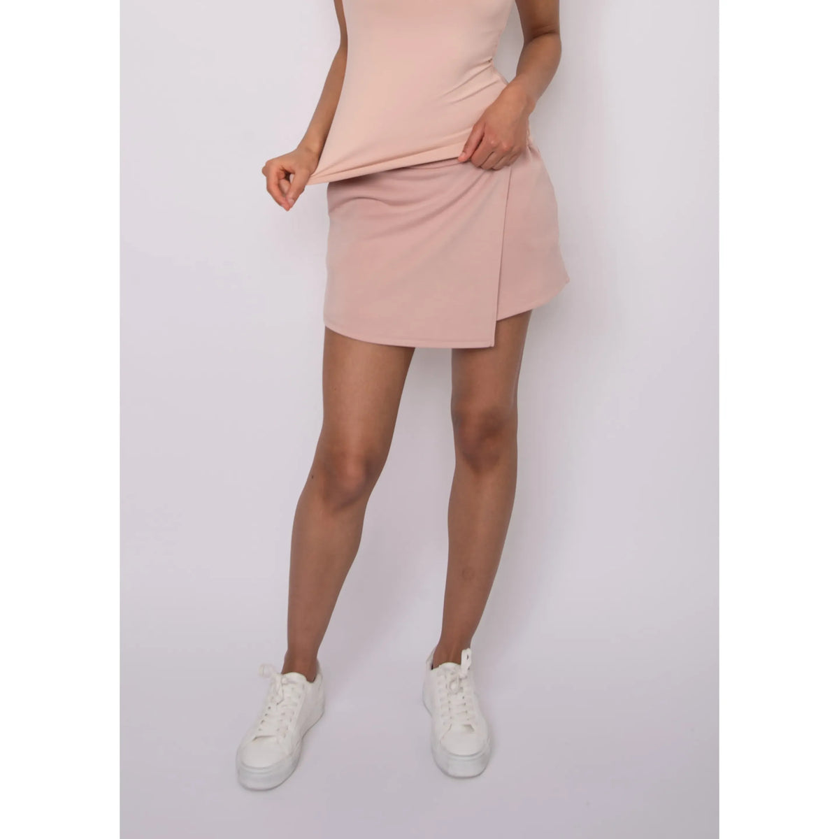 Starry Soft Knit Skort in pale pink knit, relaxed fit; model wearing white sneakers.