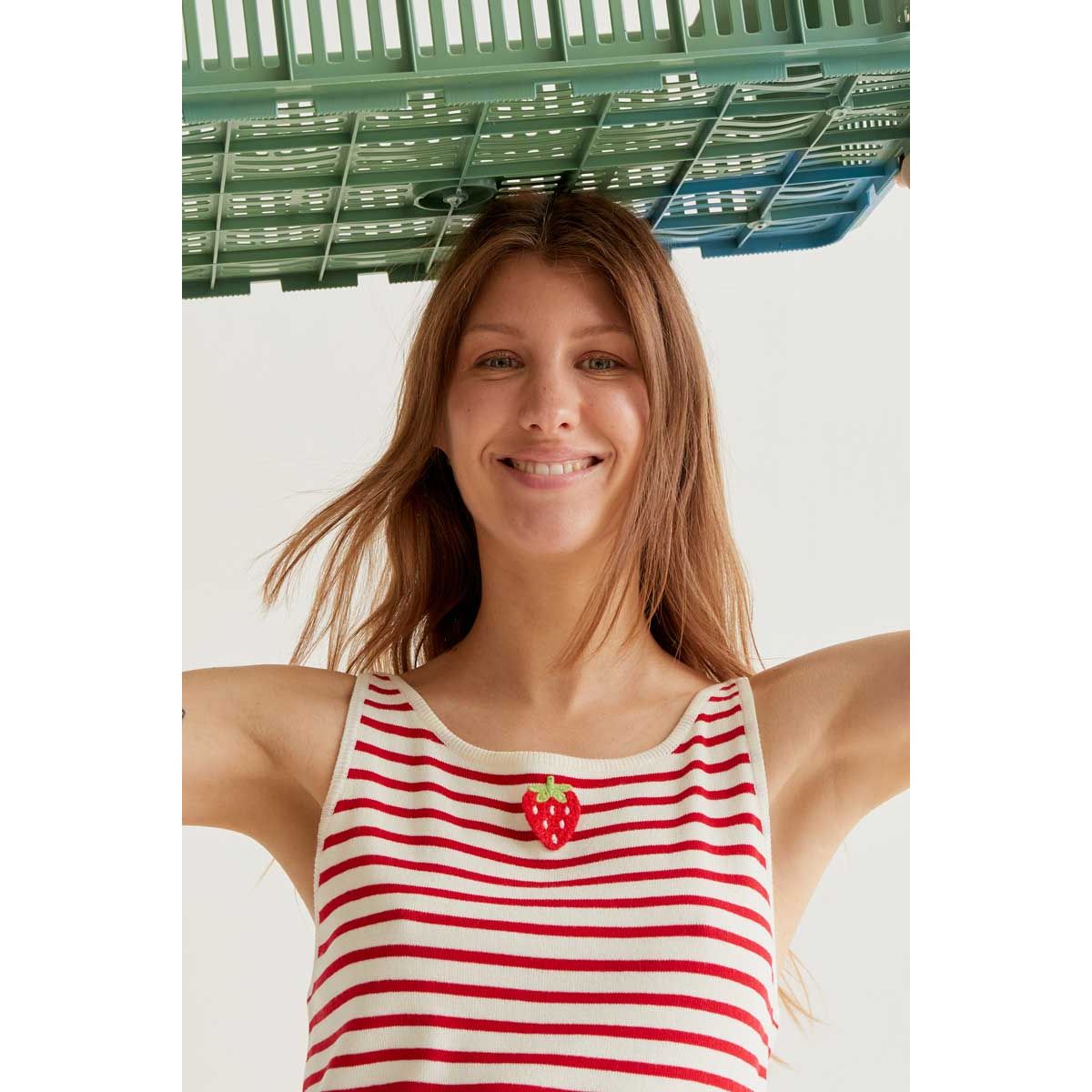 Model wearing a red-and-white striped tank with a strawberry graphic, soft viscose knit.