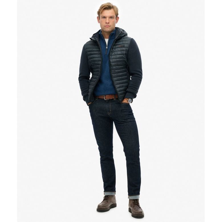Male model wearing Superdry Hooded Storm Fleece, navy padded body with plush fleece sleeves, denim jeans.