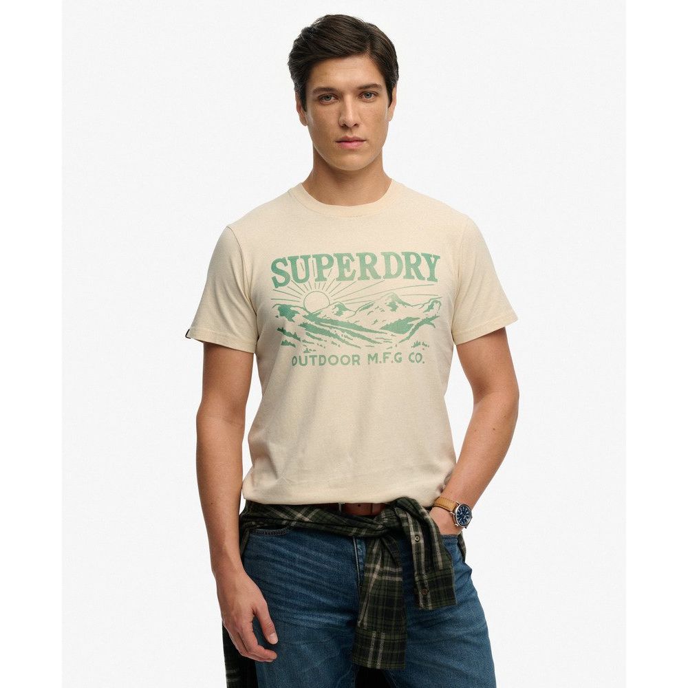 Beige Superdry Retro Outdoor Relaxed Tee with green vintage chest graphic; model in casual outdoor look.