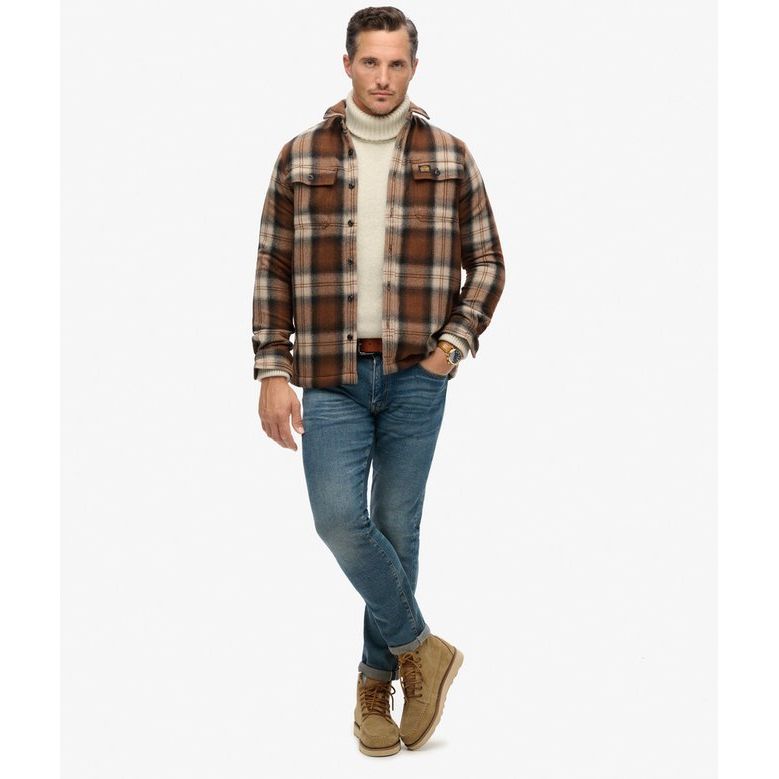 Superdry Roderick Check Wool Miller Overshirt in brown plaid with borg lining worn over cream turtleneck.