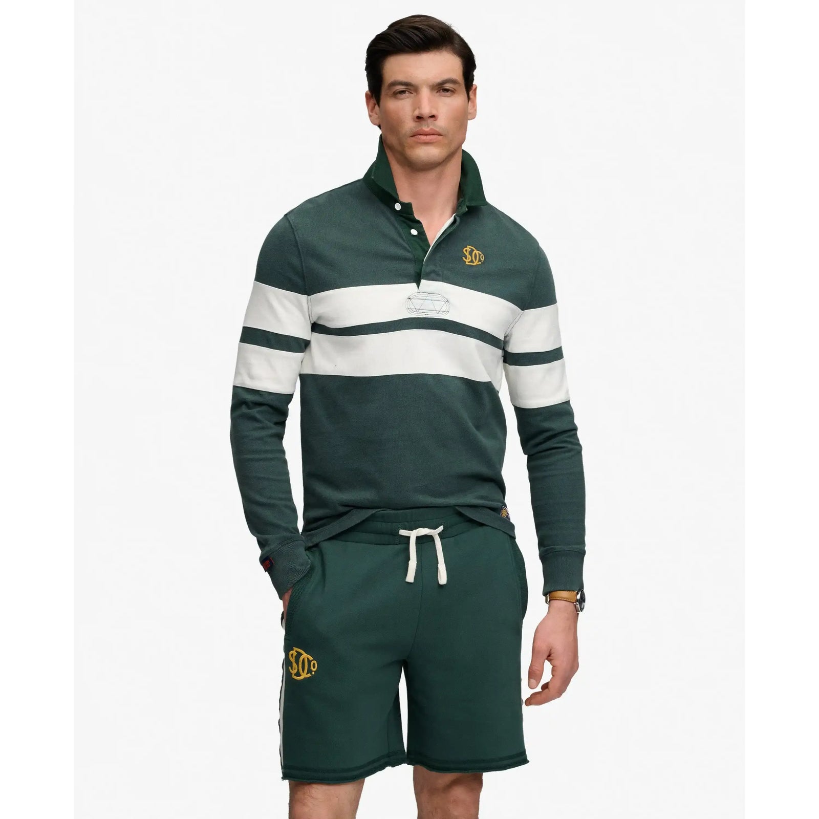 Superdry Vintage Athletic Stripe Rugby top in green with white stripes, relaxed fit, embroidered chest logo; shorts.