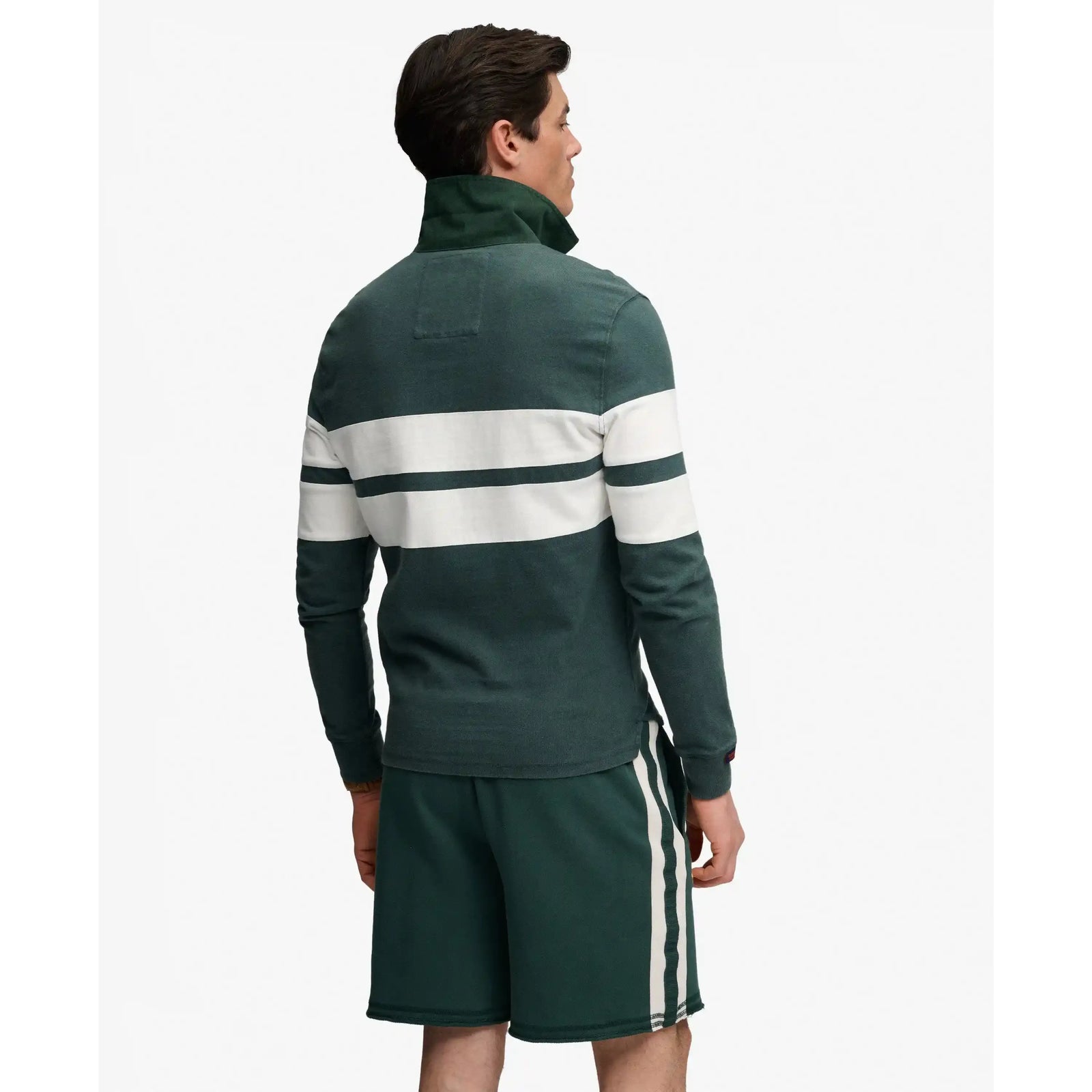 Back view of a man wearing the Vintage Athletic Stripe Rugby Top in dark green with white stripes.