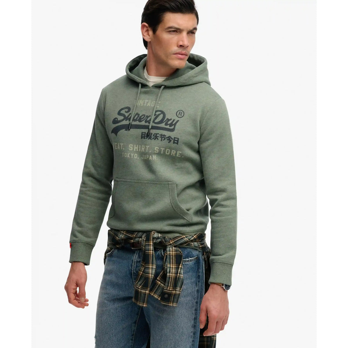 Male model in green Superdry VL Heritage Relaxed Hoodie with faded chest logo.