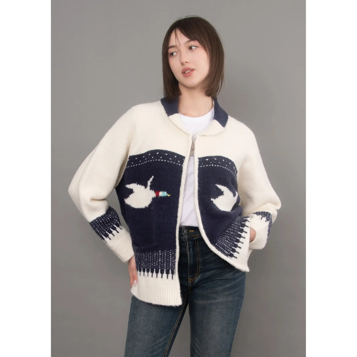 Cream and navy knit cardigan with raglan sleeves, shawl collar, and dove motif on front panels.