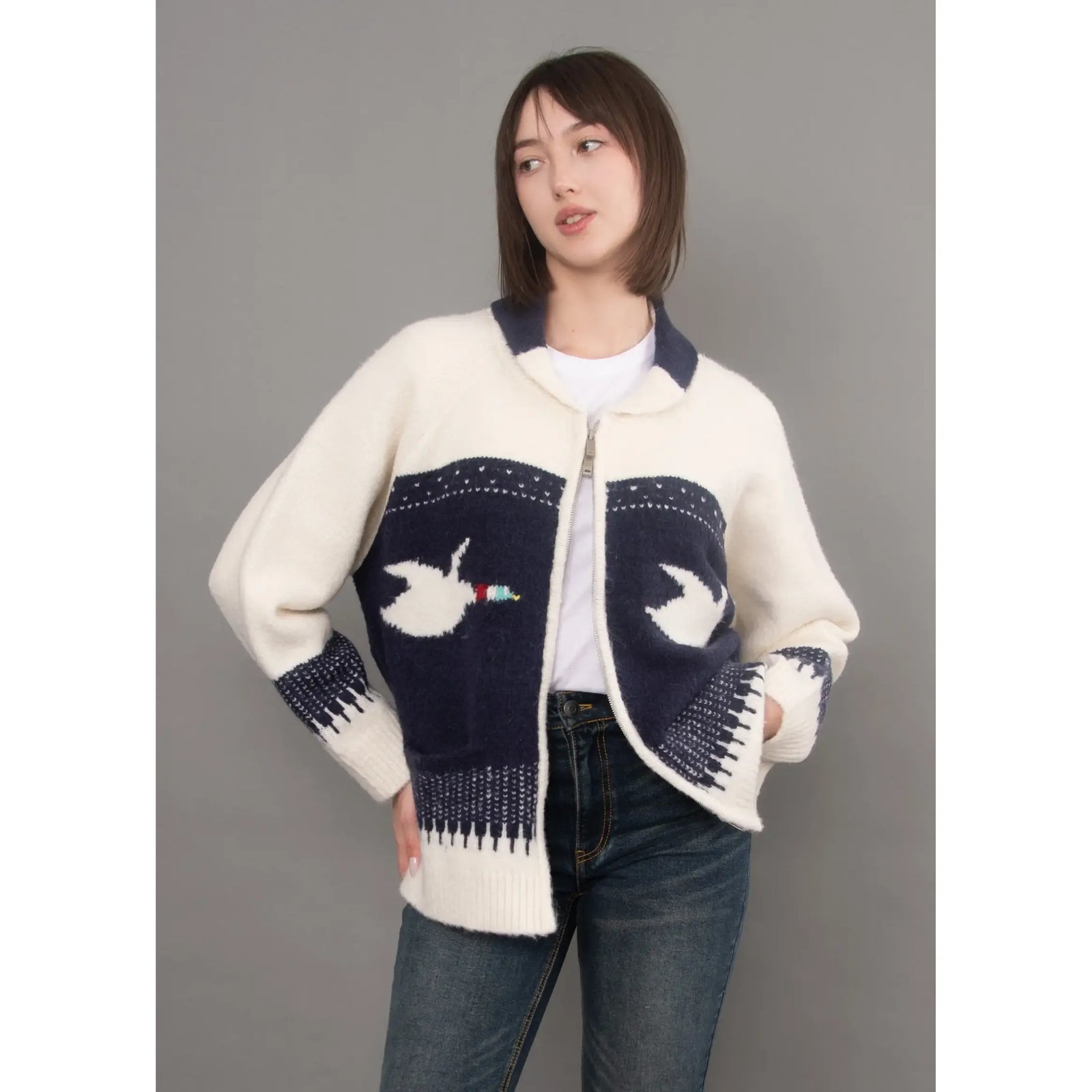 Cream and navy knit cardigan with raglan sleeves, shawl collar, and dove motif on front panels.