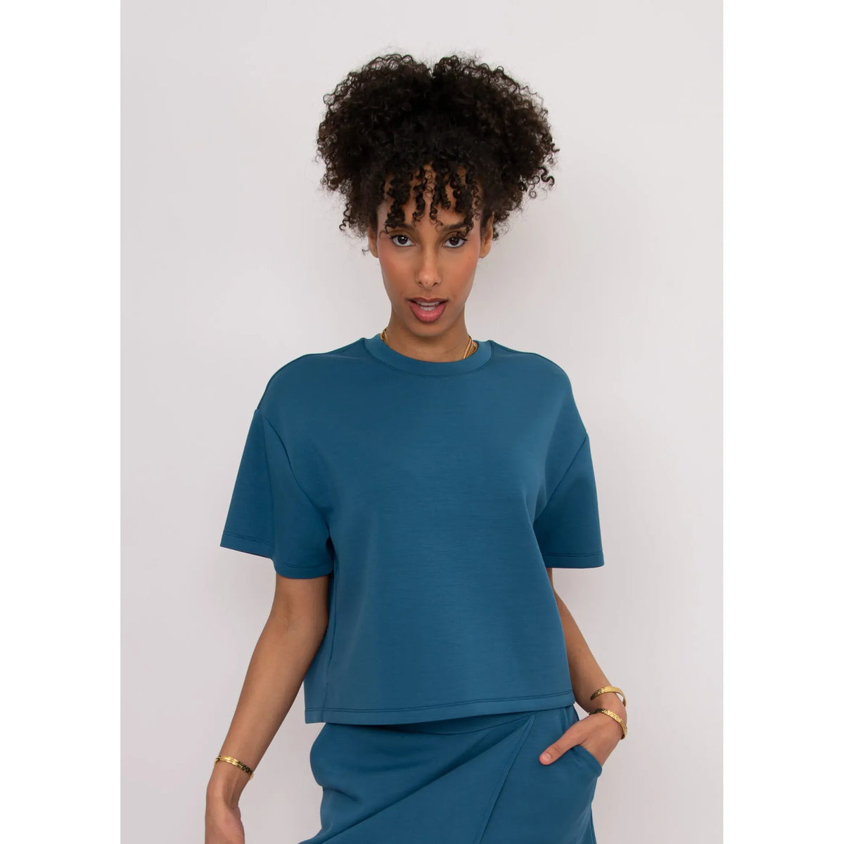 Teal Tess Soft Knit Top, a boxy ultra-soft knit with short sleeves worn by model.