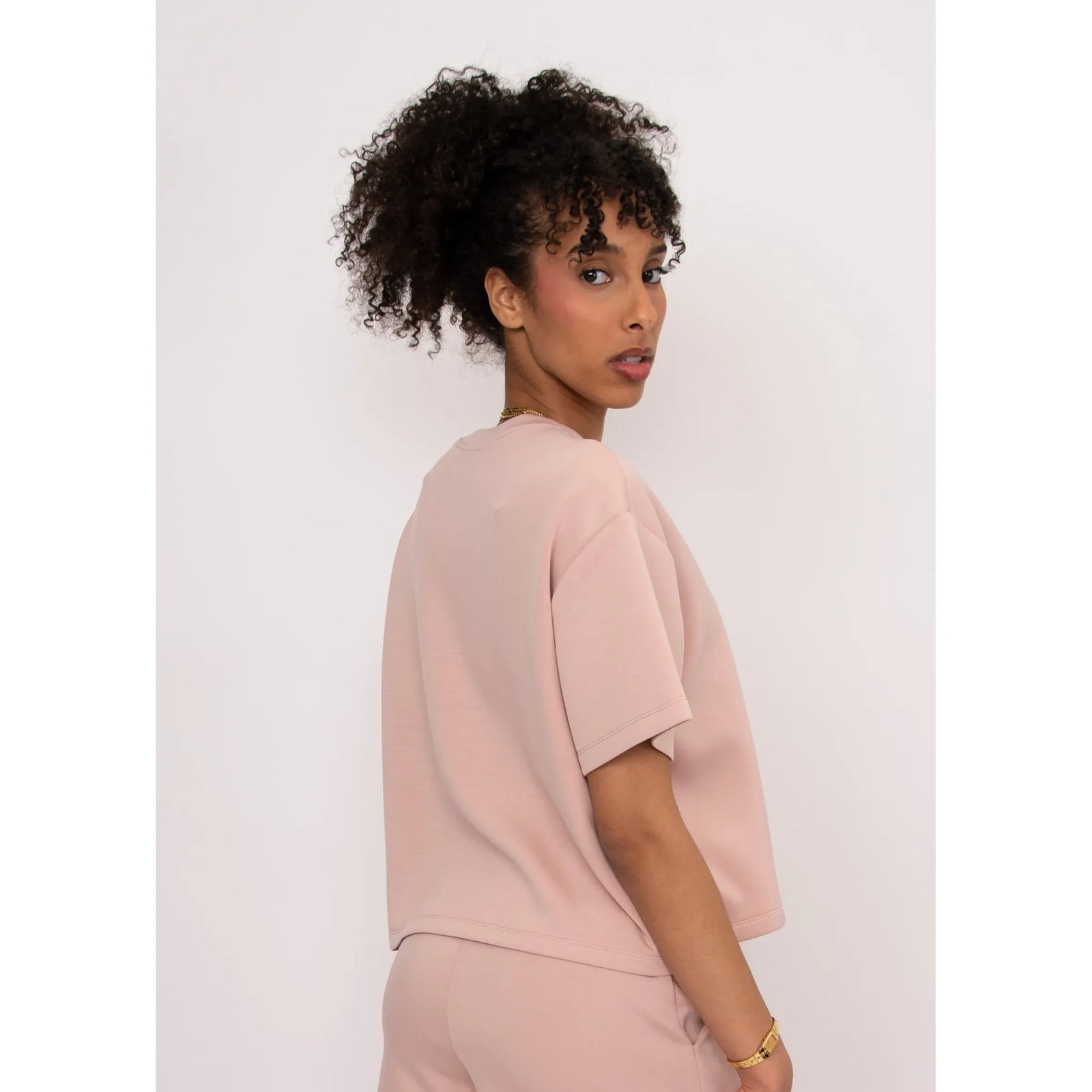 Tess Soft Knit Top in blush pink on model with curly hair, boxy relaxed fit short-sleeve knit.