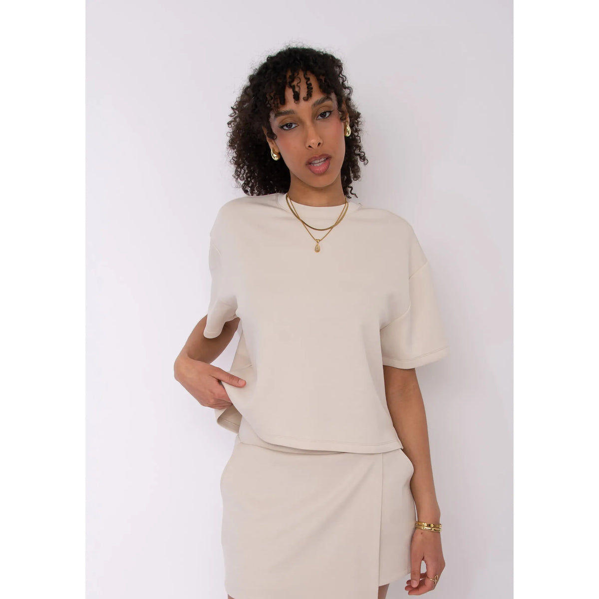 Tess Soft Knit Top in beige, boxy knit with short sleeves, model wearing size Small in a matching set.