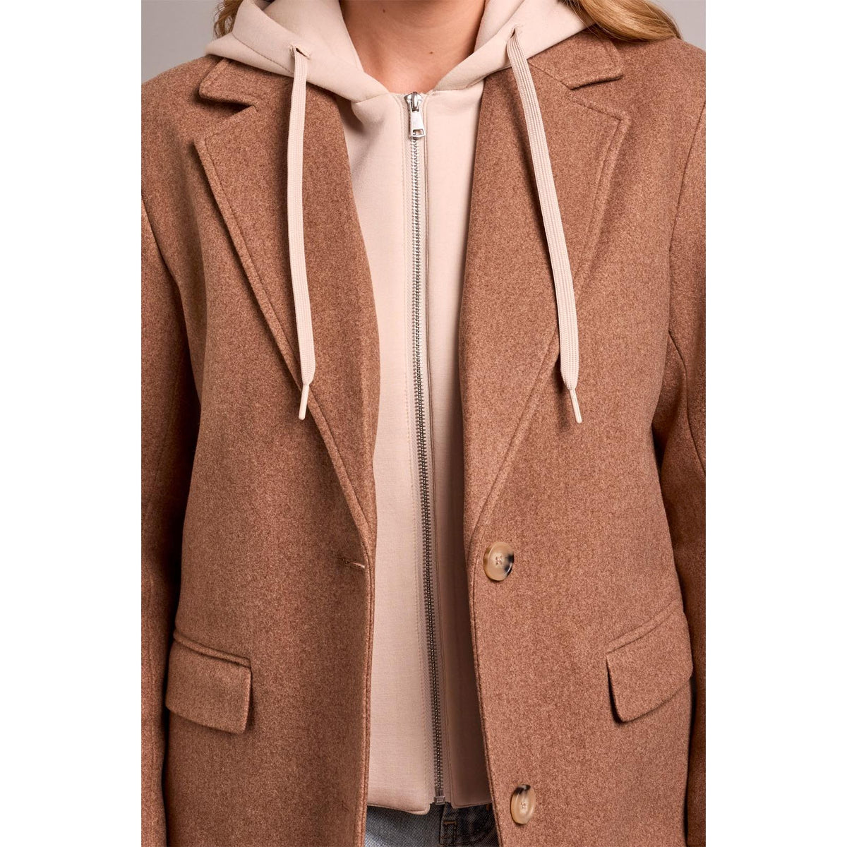 Brown tribal knit car coat with notch lapels worn over a removable beige fooler hoodie insert for versatile street style.
