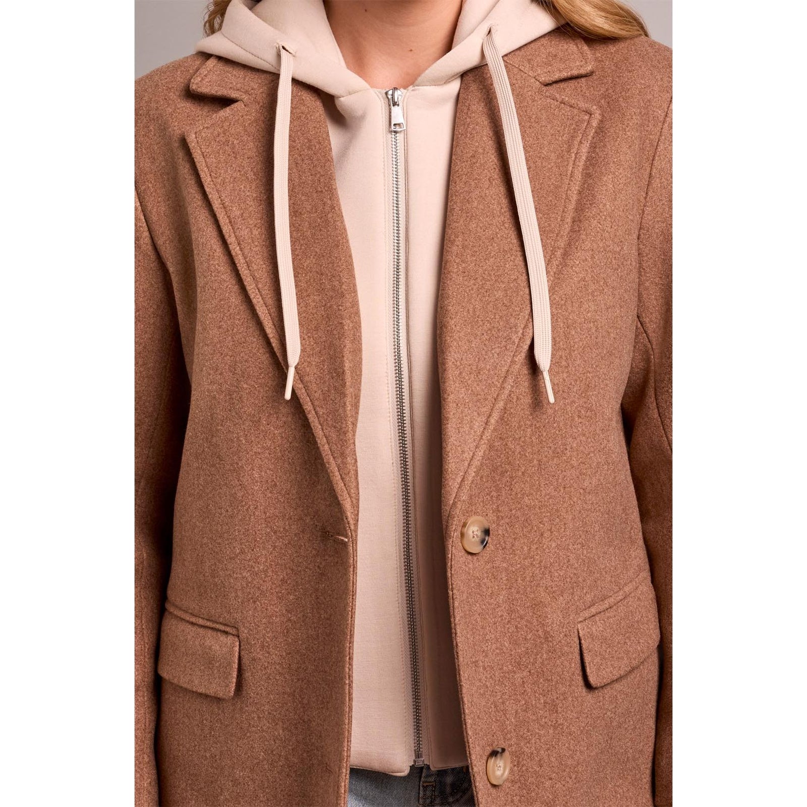 Brown tribal knit car coat with notch lapels worn over a removable beige fooler hoodie insert for versatile street style.