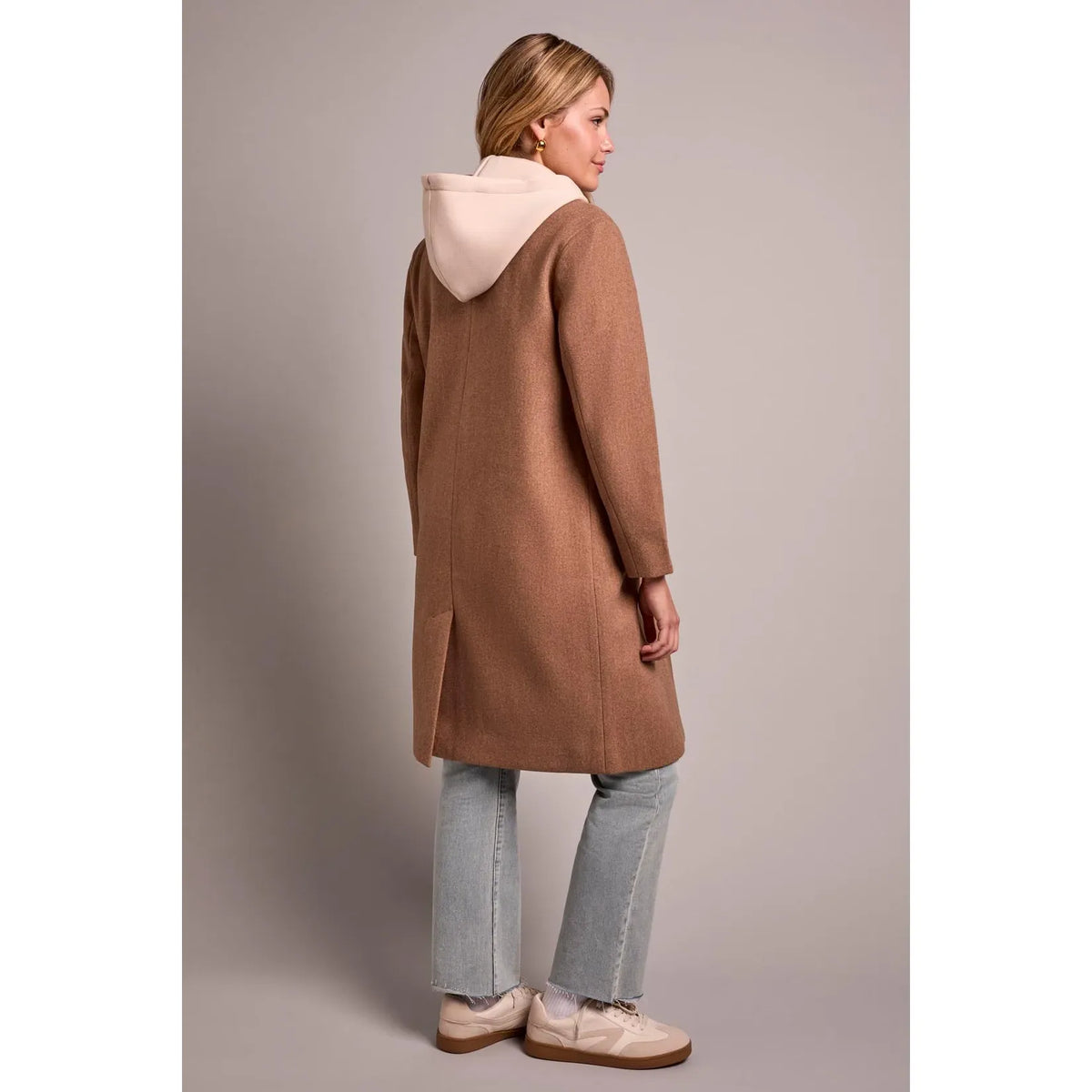 Brown tribal knit car coat with removable beige fooler hoodie insert, shown from back with side slit.