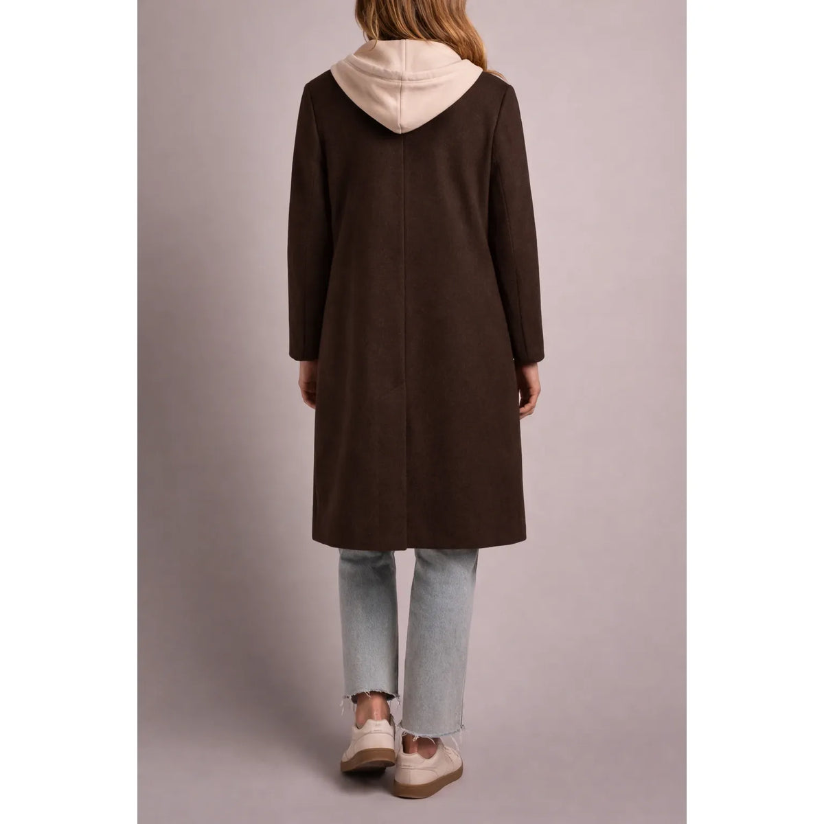 Back view of a brown tribal knit car coat featuring a cream fooler hoodie insert, paired with light wash jeans and cream sneakers.