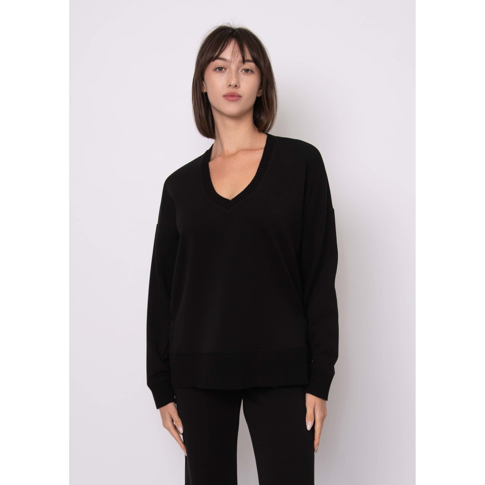 Vixie Soft Knit Vneck Sweater in black with ribbed neckline, cuffs and hem on a model.