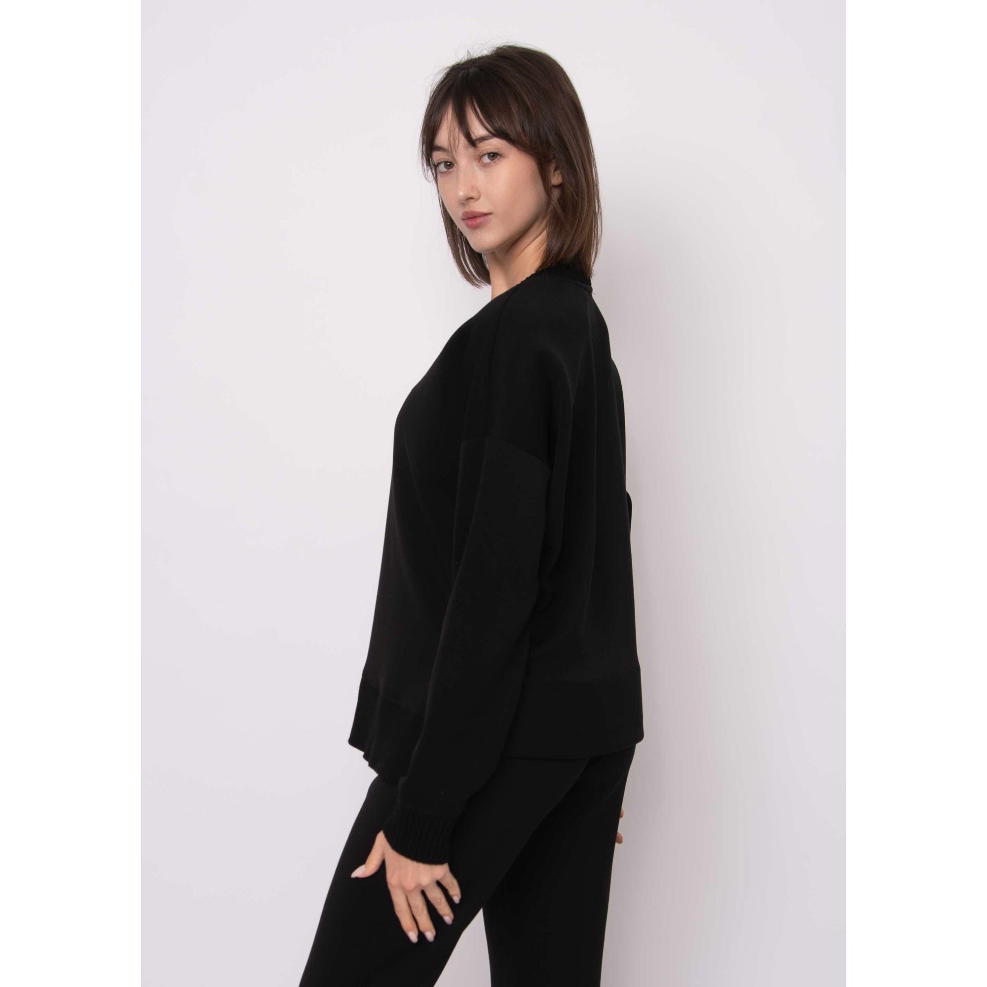 Vixie Soft Knit V-Neck Sweater worn by model; black relaxed-fit rib-knit with refined V-neck.