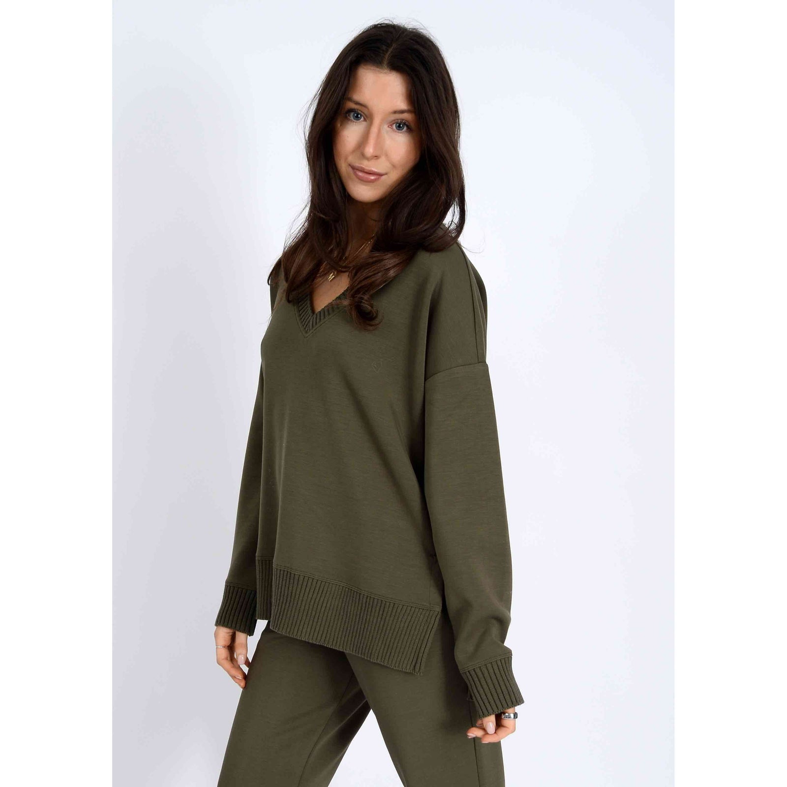 Vixie Soft Knit Vneck Sweater in olive green on a model with ribbed cuffs and hem.