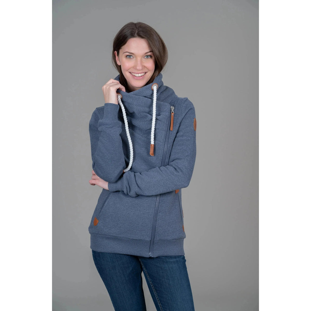 Stylish woman wearing the Wanakome Hestia Zip Up with cozy funnel neck and asymmetrical zipper, perfect for casual wear.