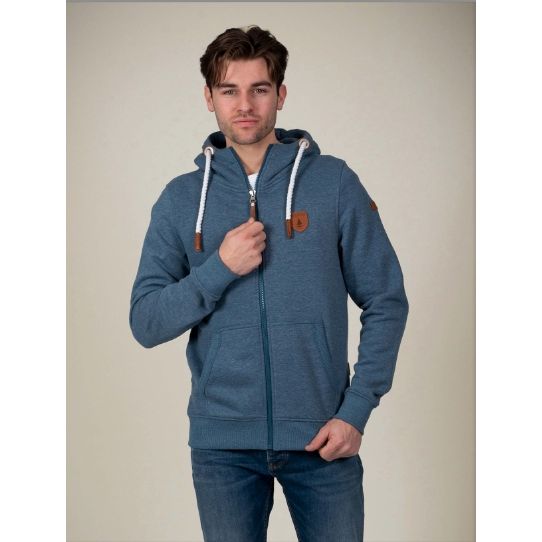 Wanakome Zeus Hoodie on a model: blue zip hoodie with white drawstrings and leather patch.