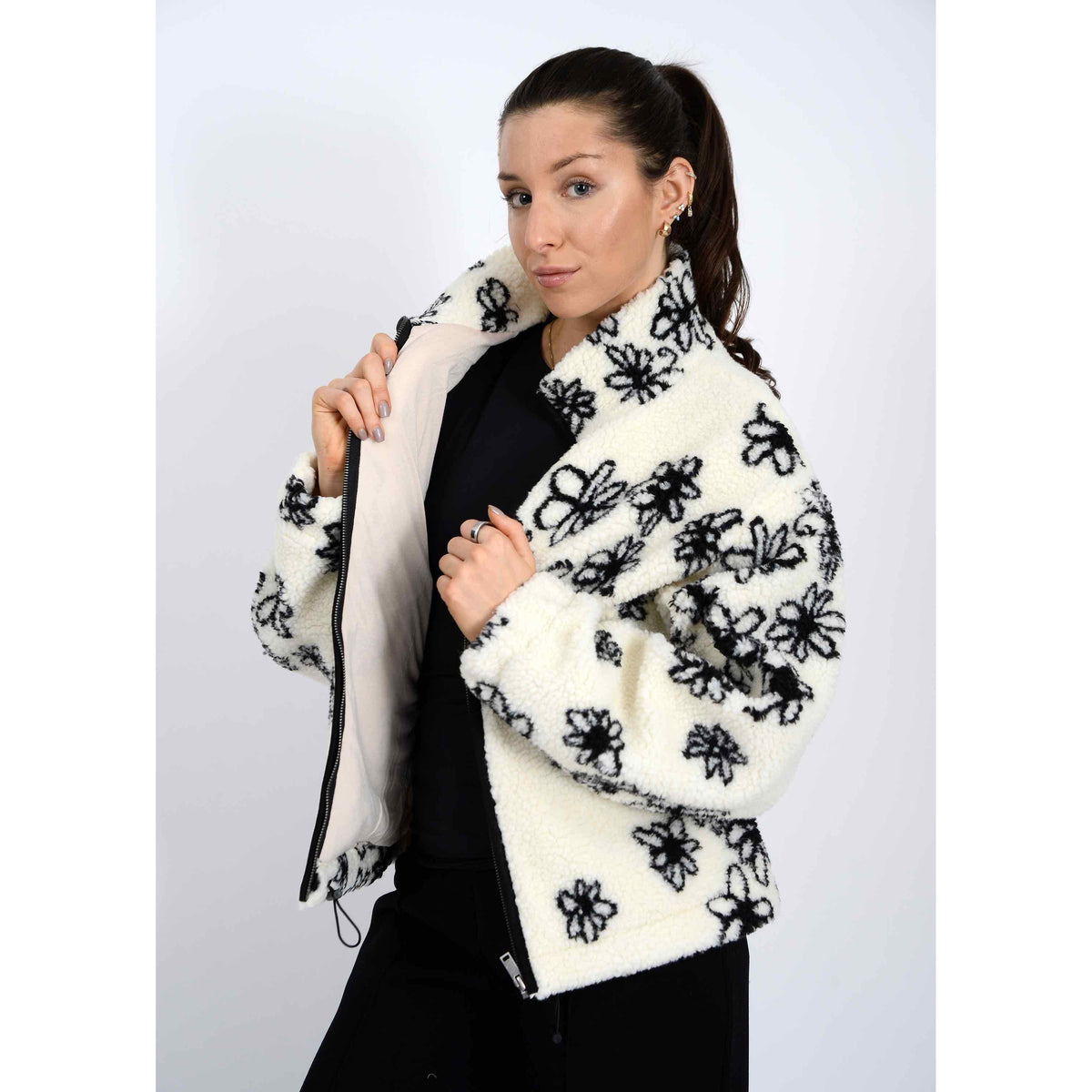 Whistler Sherpa Jacket worn by model, white fleece with black snowflake floral pattern and zip closure.