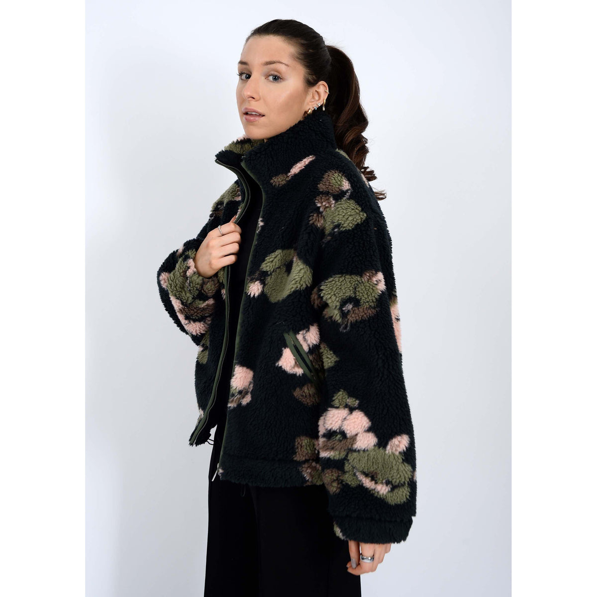 Whistler Sherpa Jacket worn by model, black teddy fabric with green-pink camo, collar, zip closure, drawstring hem