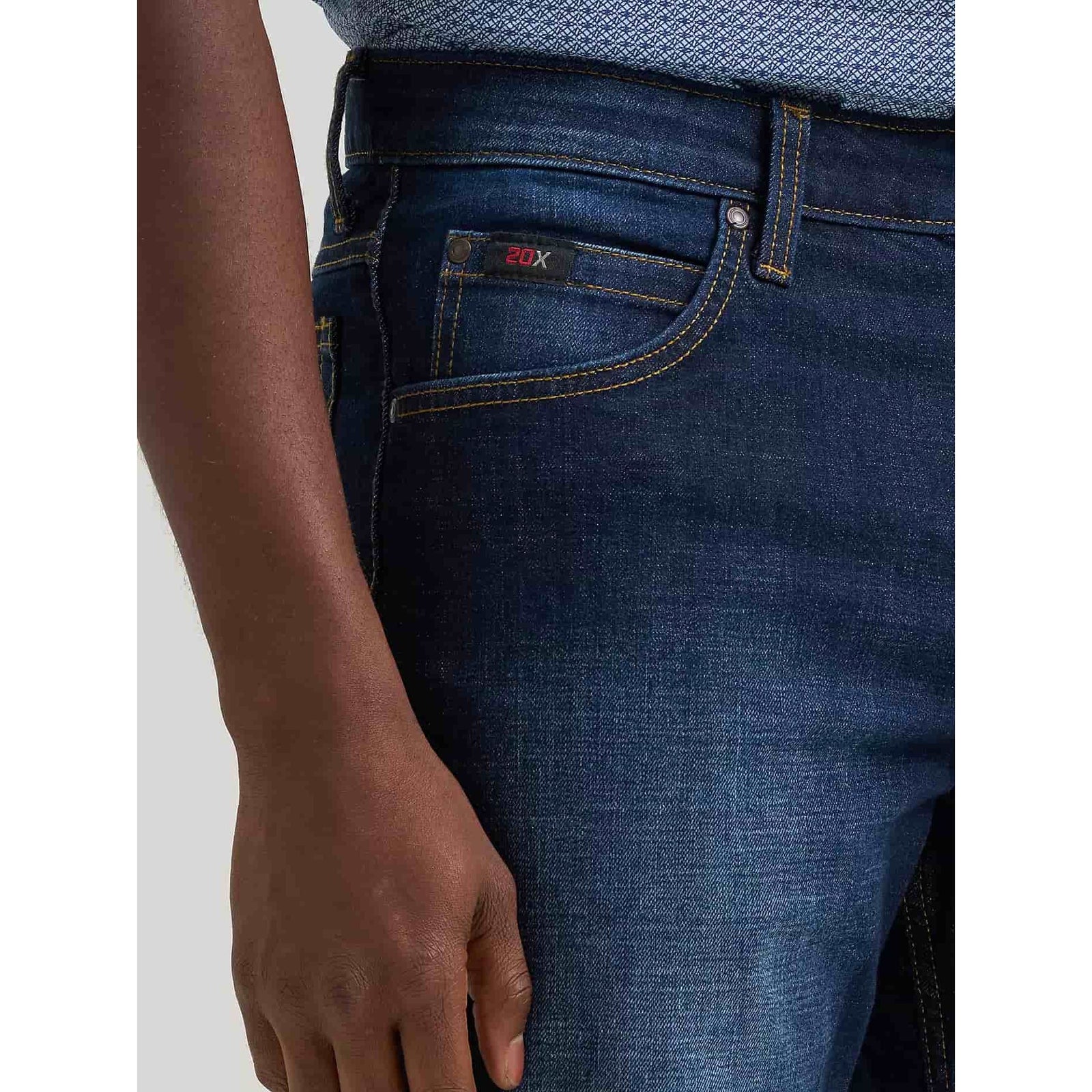 Wrangler 20X Active Flex jeans in Twilight denim, close-up of front pocket with 20X patch and yellow contrast stitching.