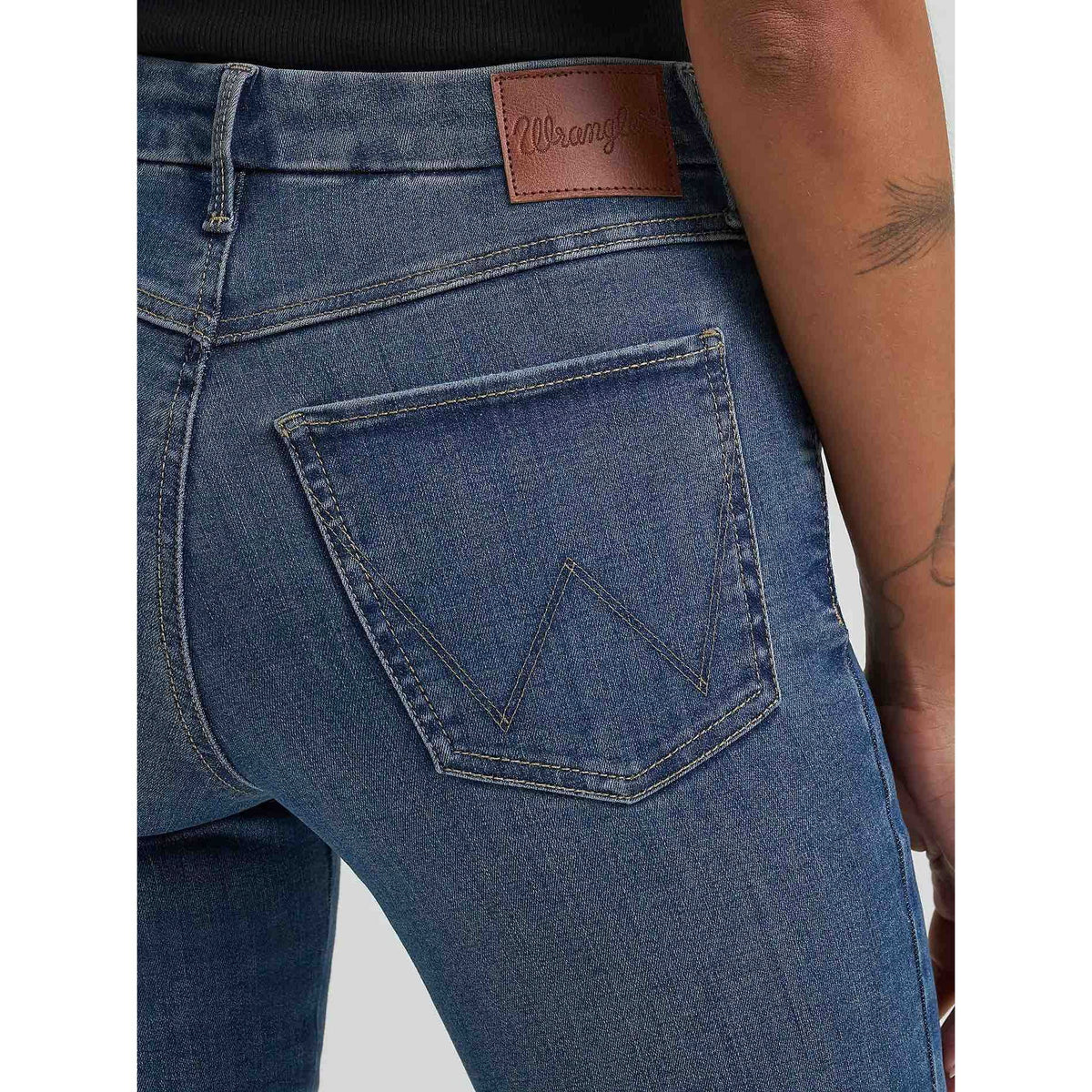 Back view of Wrangler Bespoke Flare in Lily jeans, blue denim with angled back pockets and leather patch.