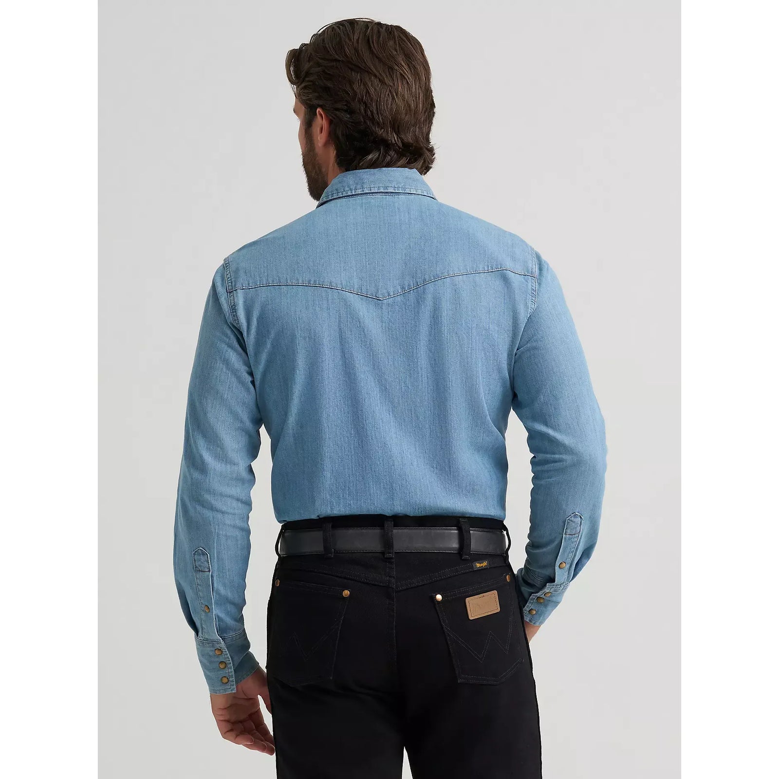 Back view of a man wearing a light-wash Wrangler Classic Denim Snap Shirt with western yoke stitching