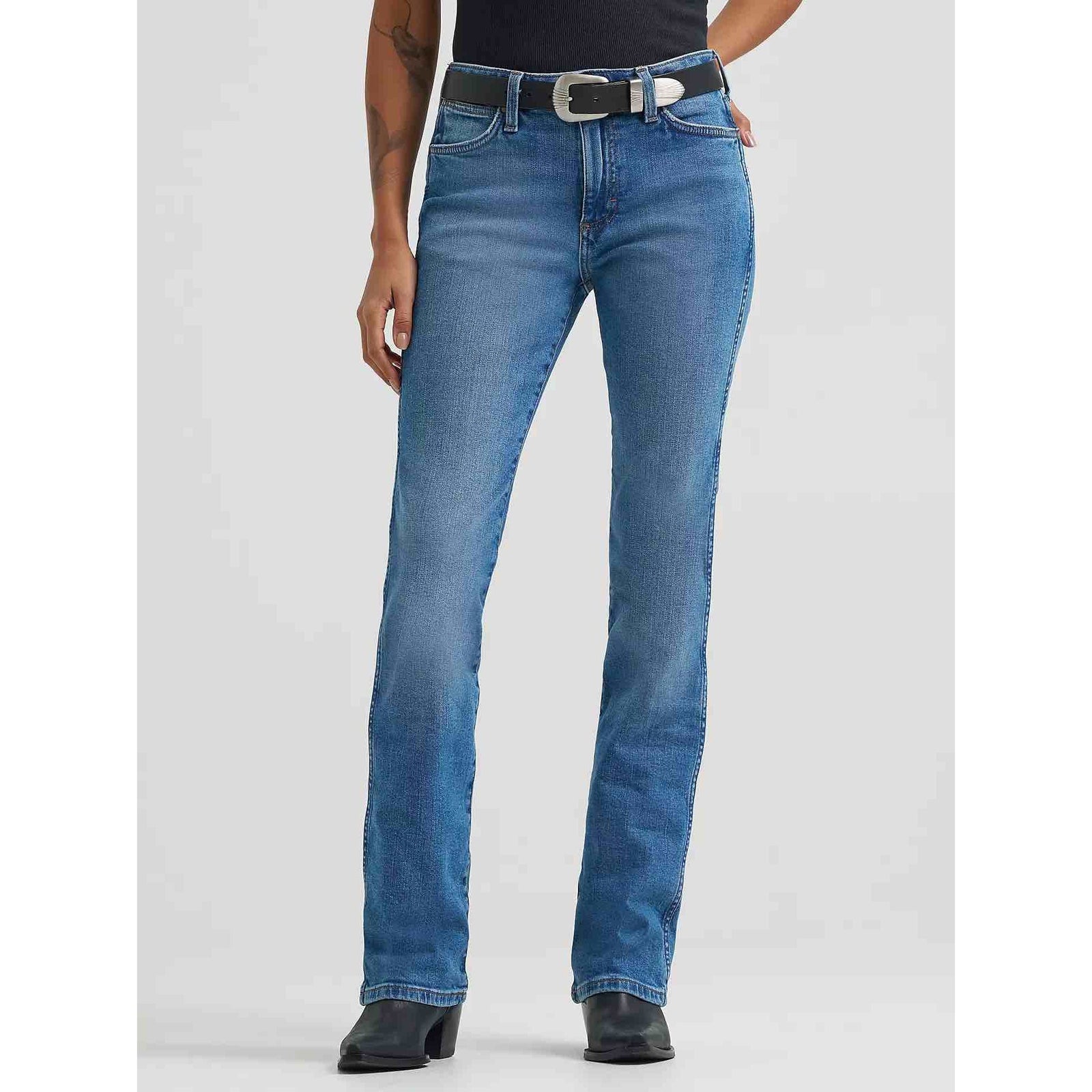 Women's Wrangler Retro Bailey High Rise Bootcut Jeans with a black belt, designed to fit over boots.