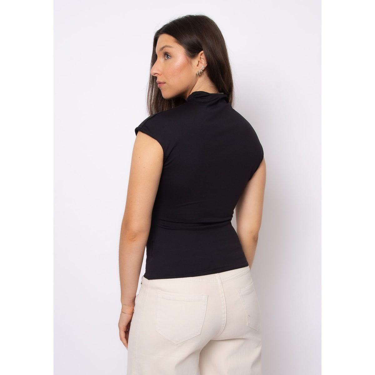 Back view of a model wearing Yvette Funnel Neck Draped Top in black, sleeveless with a refined neckline.