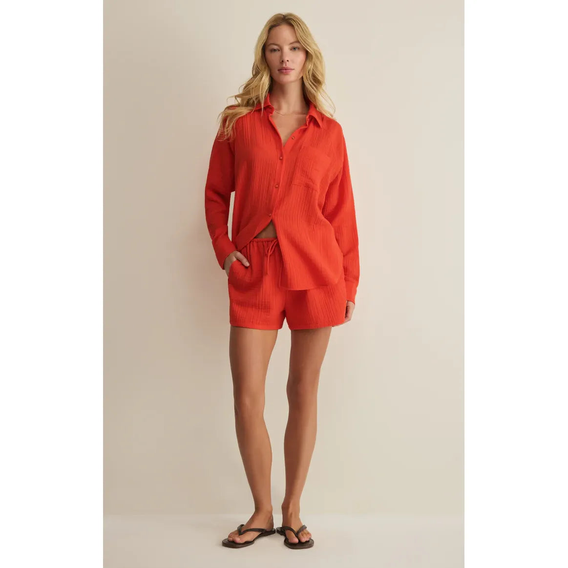 Model wearing coral Z Supply Daylight Airy Shorts set with matching lightweight top, drawstring waist and pockets.