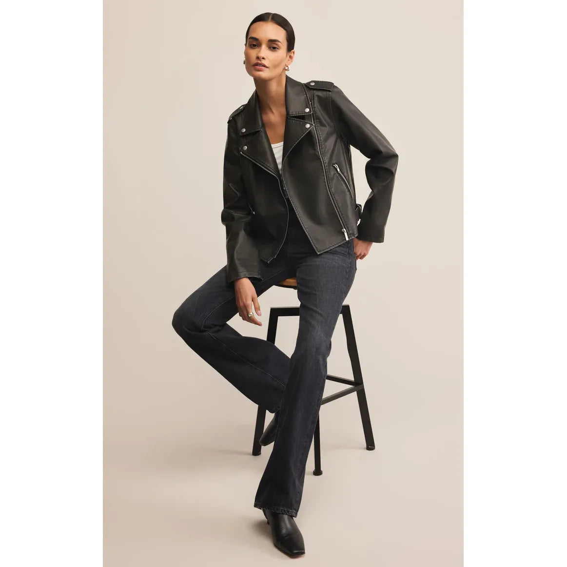 Z Supply Alchemy Faux Leather Moto Jacket worn by model; sleek black faux leather with zip front pockets.