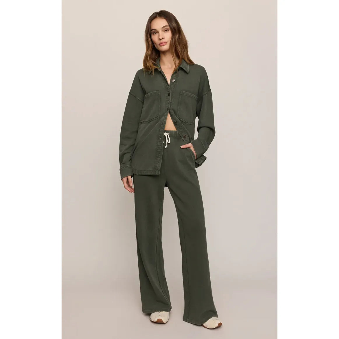 Model wears olive green Z Supply All Day Knit Jacket with chest pockets and matching wide-leg drawstring pants for a timeless, casual look.