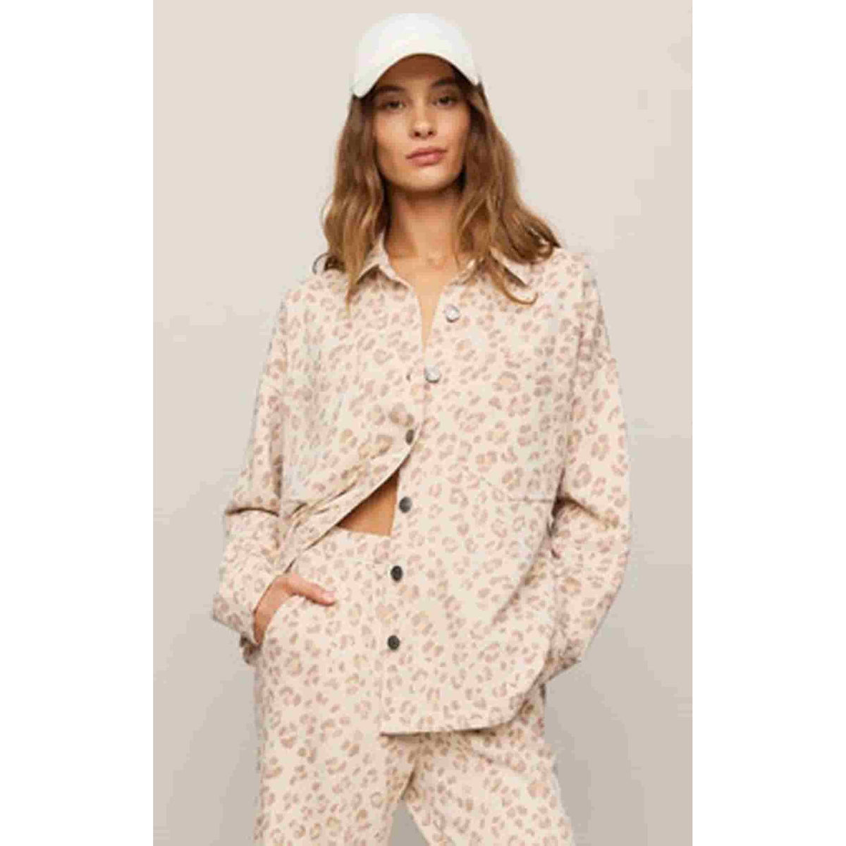 Model wearing pale pink floral button-front shirt jacket with long sleeves.