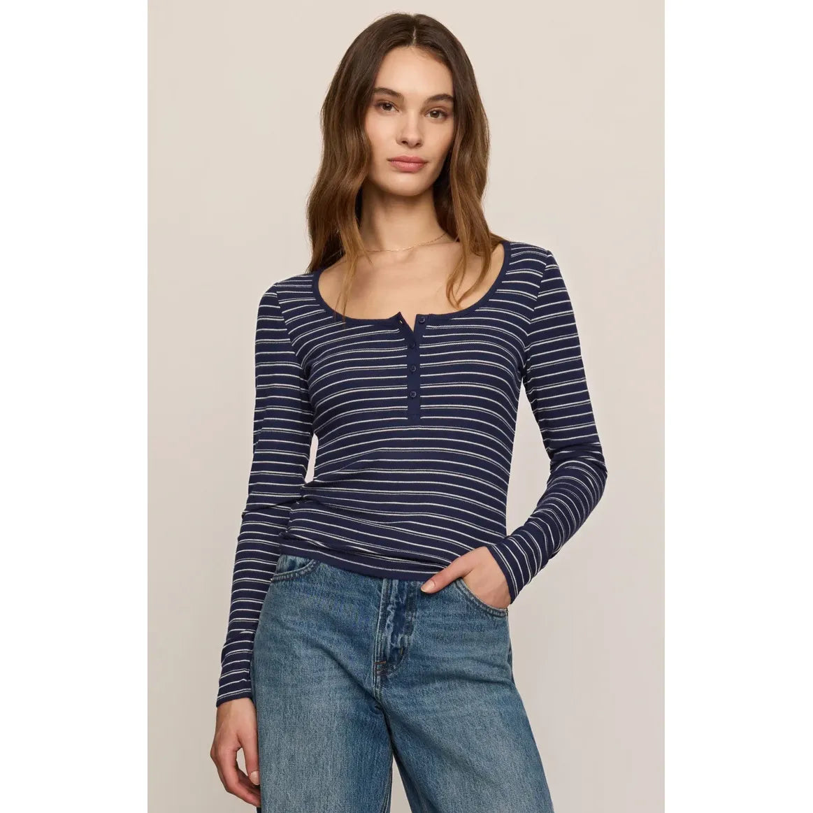 Navy and white striped long-sleeve henley top with scooped neckline and button placket, paired with blue jeans.