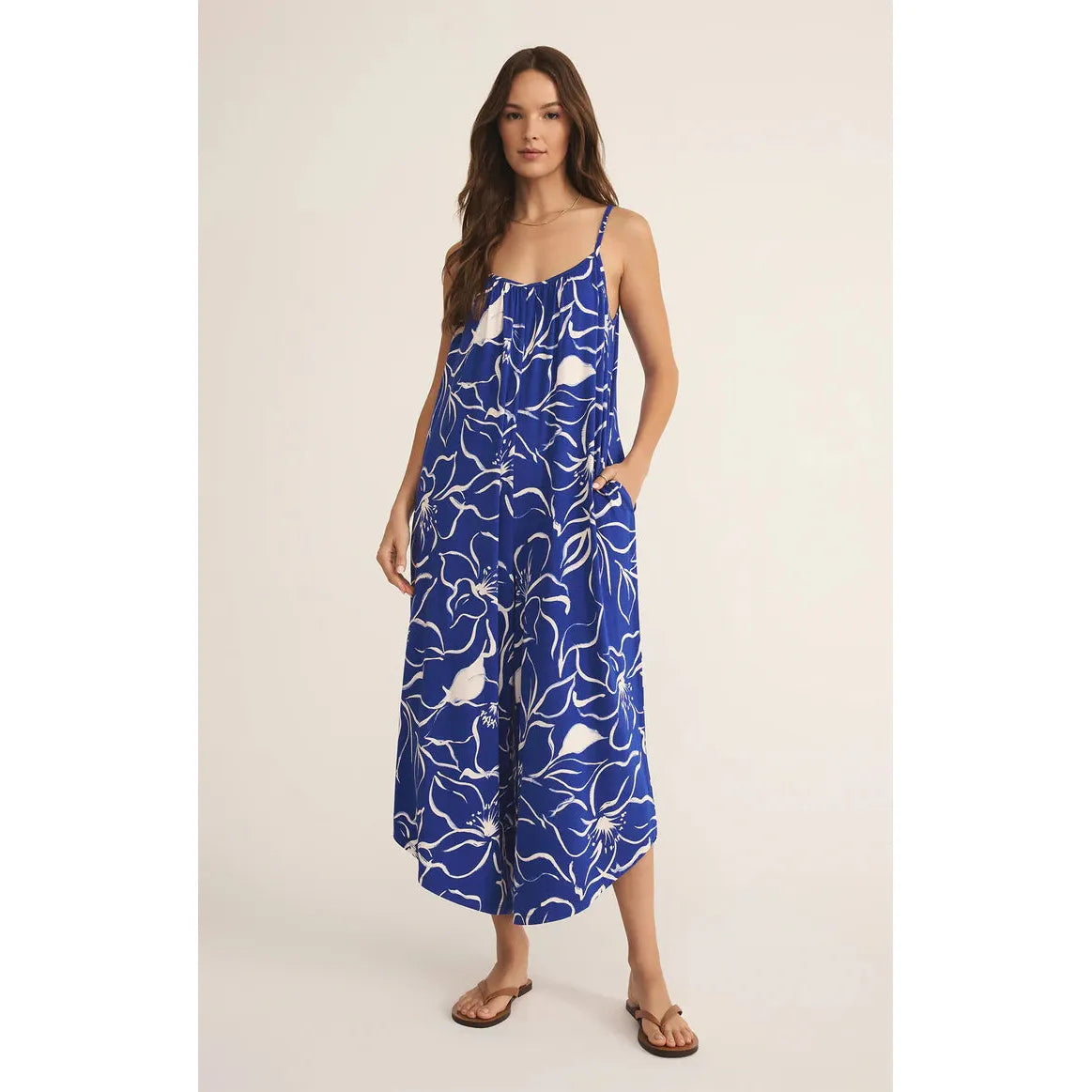 Z Supply Cala Floral Jumpsuit features a vibrant floral print, scoop neck, and practical side pockets for effortless style.