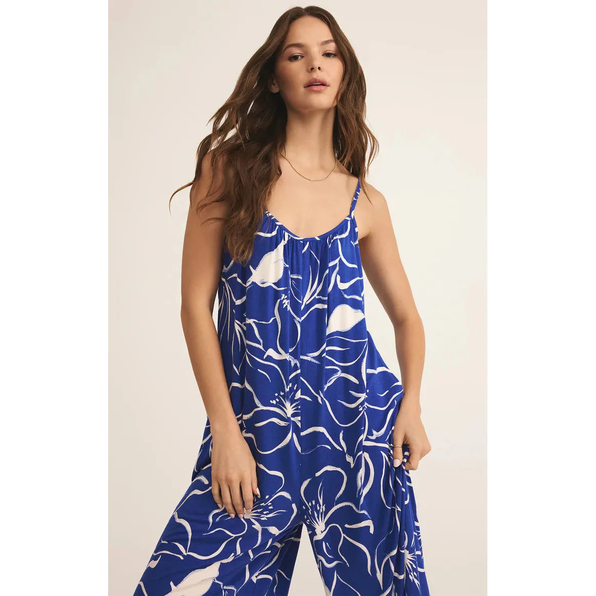 Stylish Z Supply Cala Floral Jumpsuit in vibrant blue, perfect for a relaxed vacation look with adjustable straps.