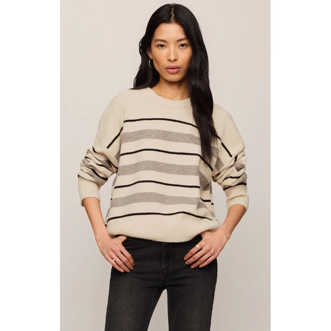 Cream Cirrus striped sweater with grey and black horizontal bands, featuring a relaxed fit and ultra-soft cozy yarns.