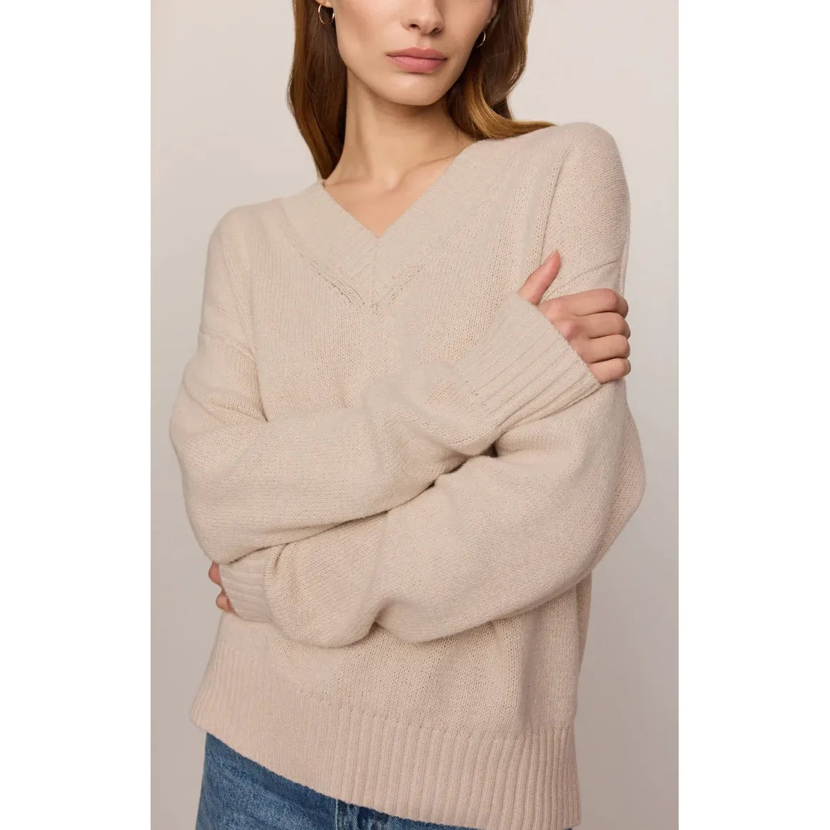 Model wearing a frosted pearl Z Supply Cloud Spun V-neck sweater with a relaxed fit and ribbed cuffs and hem.