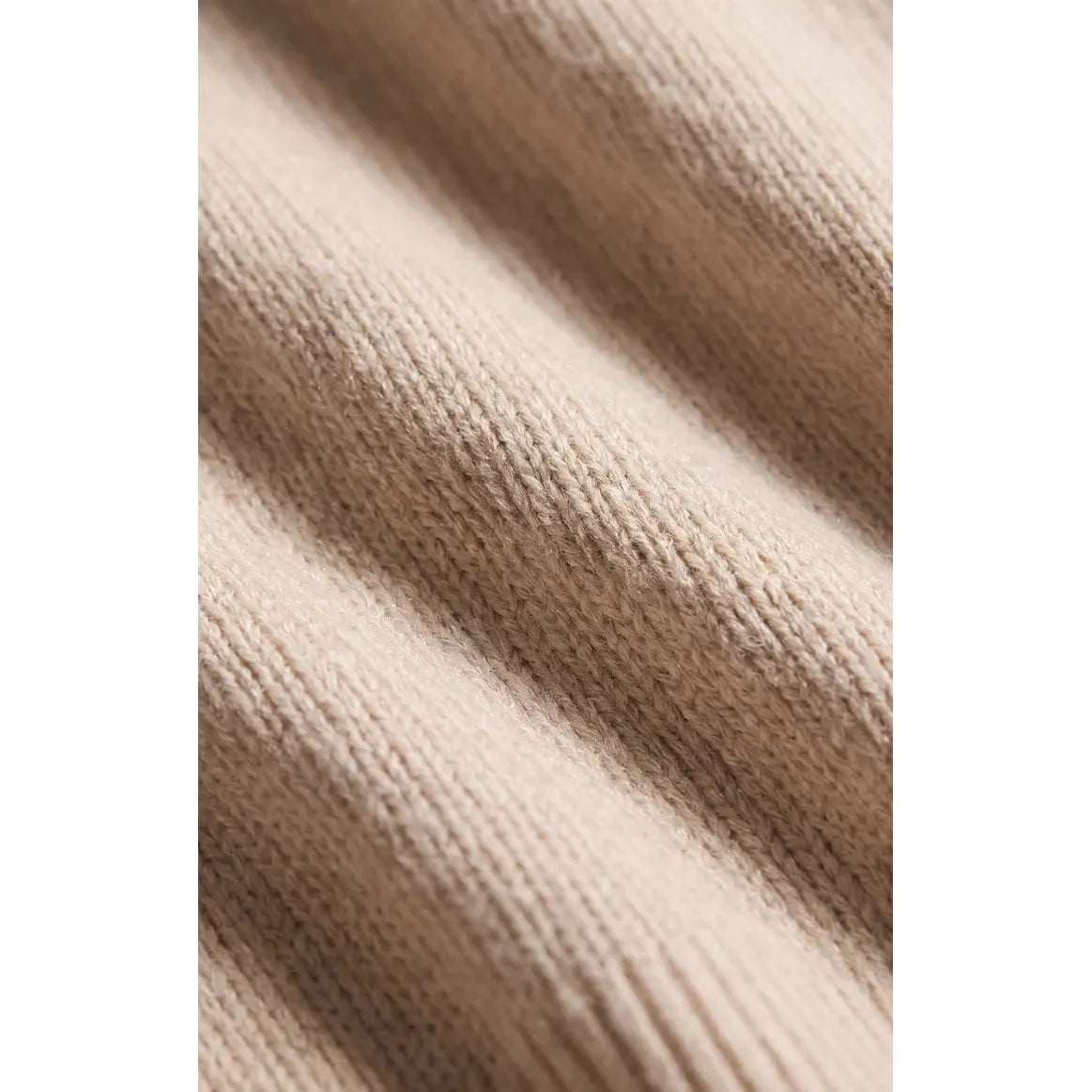 Soft frosted pearl Cloud Spun V-neck sweater knit. Relaxed drape, lightweight structure, and cozy texture in neutral beige.