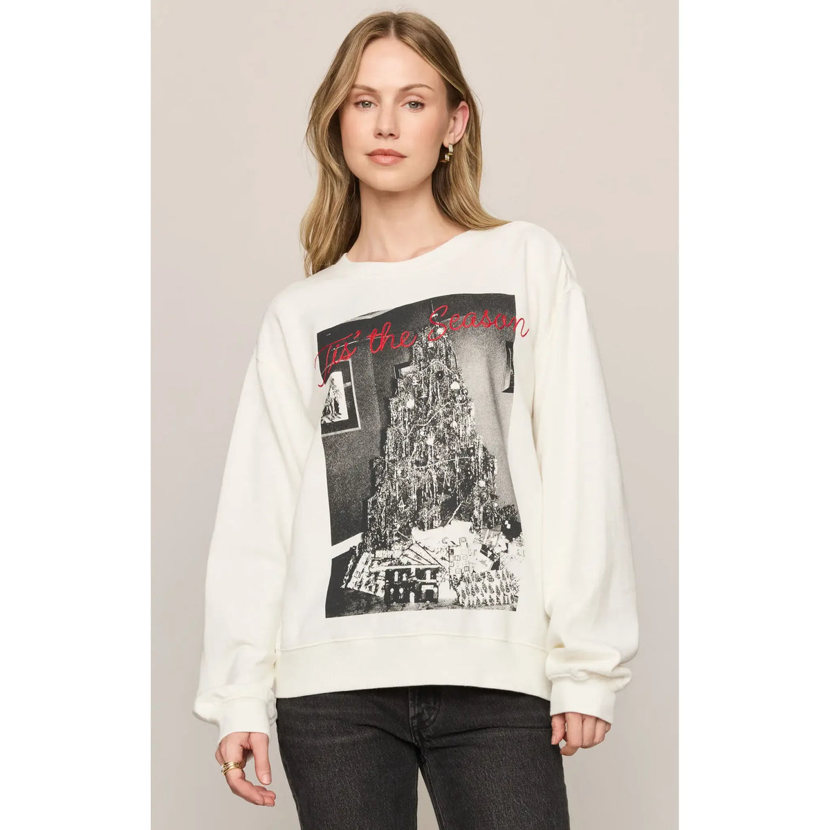 Cream oversized crewneck sweatshirt featuring black and white Christmas tree graphic with red "Tis' the Season" script text.