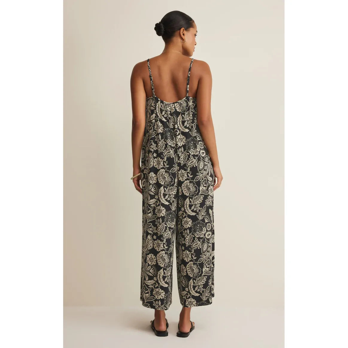 Back view of Z Supply Day Off Luz Jumpsuit in black floral print, thin straps, relaxed wide-leg silhouette.