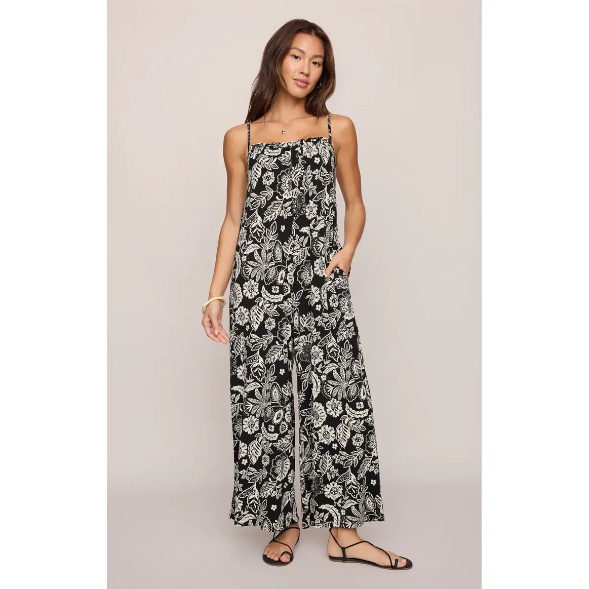 Z Supply Day Off Luz Jumpsuit in black floral print with spaghetti straps, pockets, relaxed straight leg.
