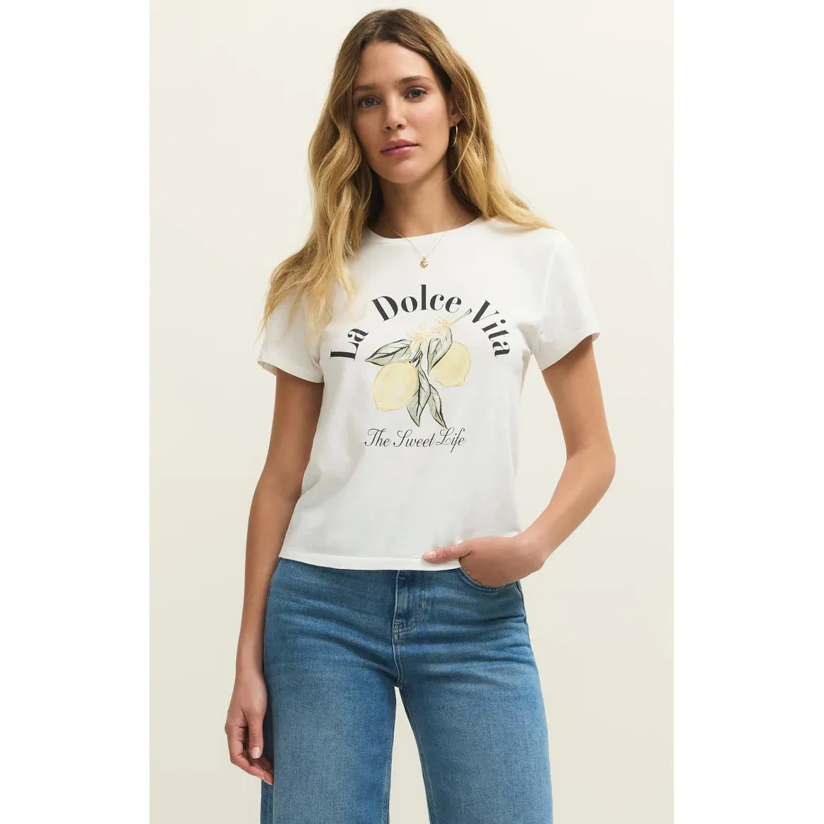 Woman wearing White Z Supply Dolce Tourist Tee with lemon motif and retro typography, relaxed fit.