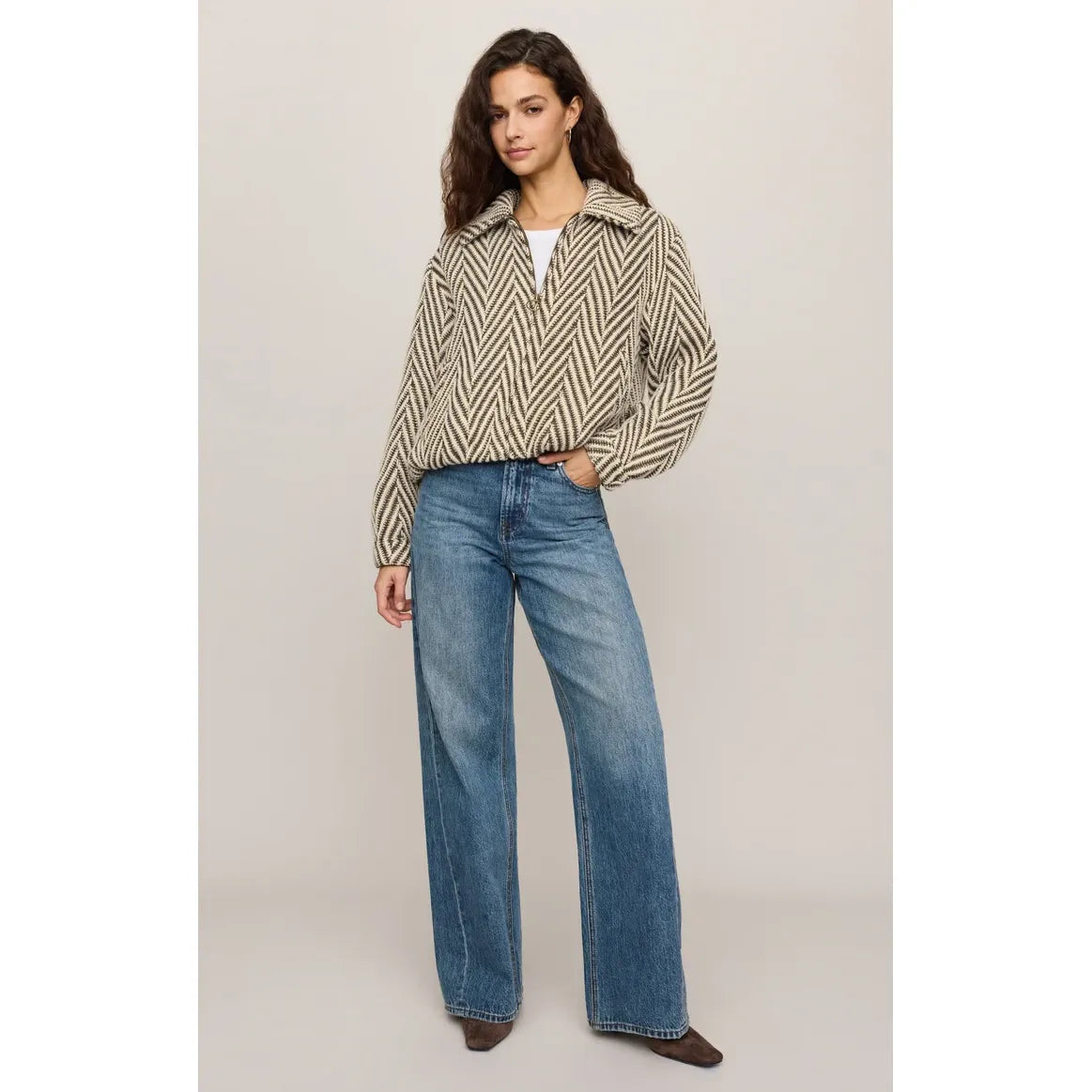 Vintage-inspired herringbone bubble jacket with antique brass zip, snap cuffs, and effortless silhouette paired with wide-leg jeans.