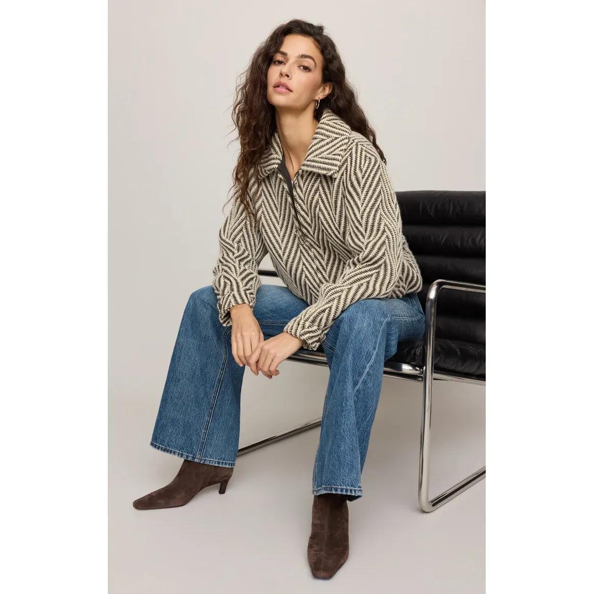Vintage-inspired herringbone bubble jacket with antique brass zip, snap cuffs, and effortless silhouette paired with wide-leg jeans.